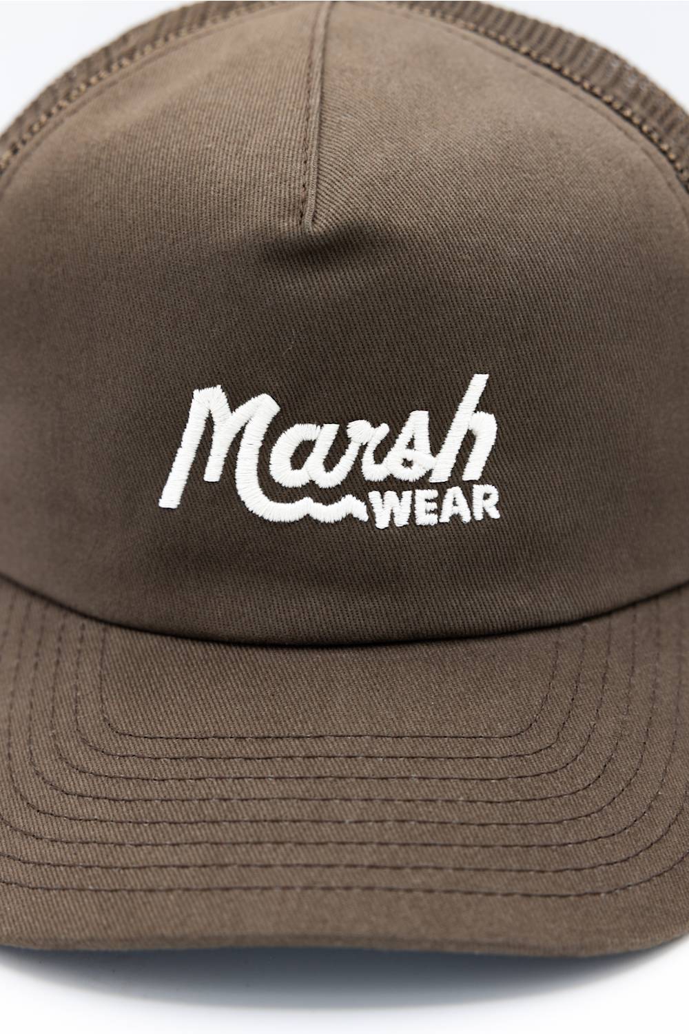 A man wearing a brown trucker hat with 'Marsh Wear' embroidered in white on the front, paired with a brown hoodie, against a plain white background.