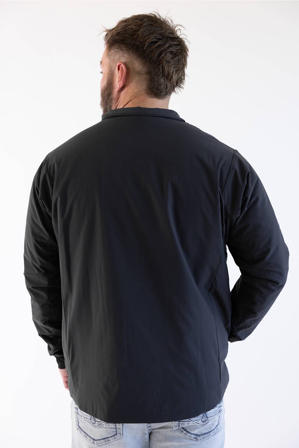 Back view of a man in front of a white background in a  black jacket