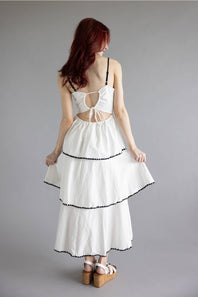 Open Back Tiered Midi Dress for Women in Off White; Woman wearing a white dress with cut-out back design on a gray background