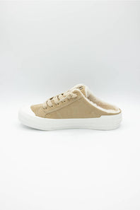 A single low-top slip-on sneaker in beige canvas with a white rubber sole, shown from the side on a light gray background.