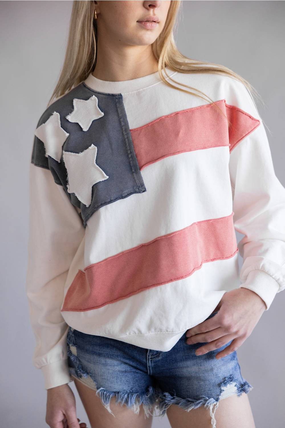 Flag USA Sweatshirt for Women in White; Person wearing a sweatshirt with an American flag design against a plain background