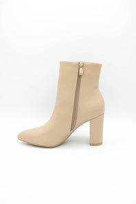 A beige ankle boot with a block heel and side zipper, shown from a side profile view on a white background.