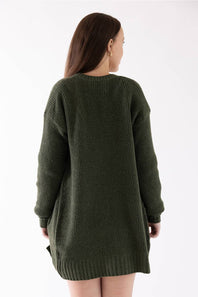 A woman viewed from the back wearing an oversized, textured waffle-knit sweater dress in olive green against a plain white background.
