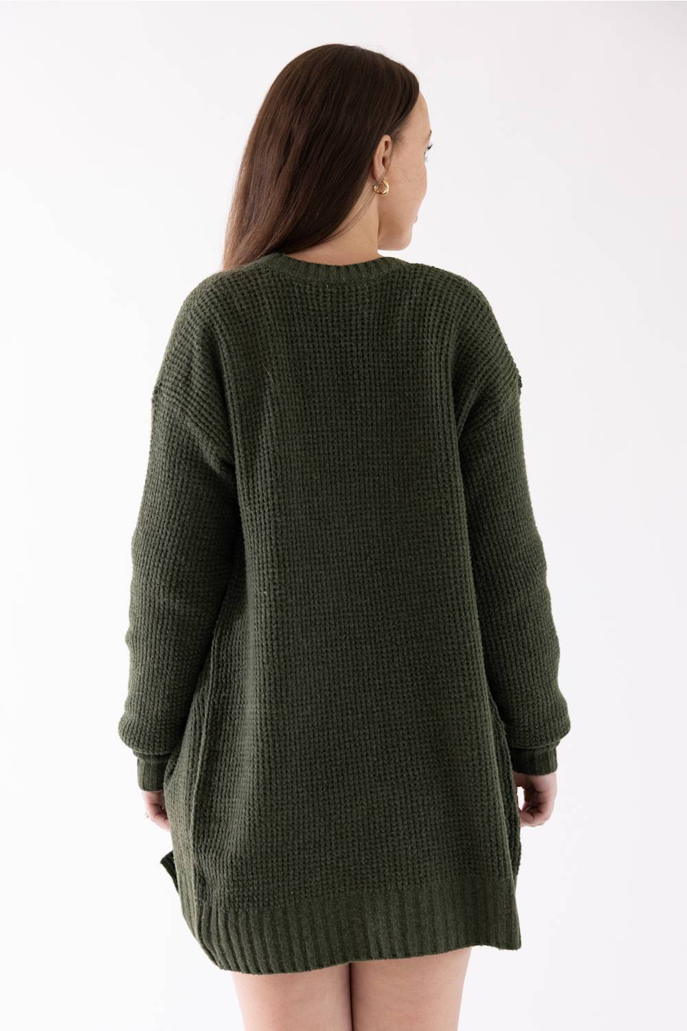 A woman viewed from the back wearing an oversized, textured waffle-knit sweater dress in olive green against a plain white background.