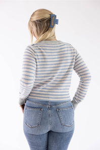 back view of a woman wearing a striped sweater and medium washed jeans