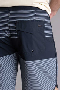 Close-up of a person wearing black and gray striped shorts with a visible brand logo, showing the back pocket of the Quiksilver SurfSilk Tijuana 19" Boarshorts for Men in Black