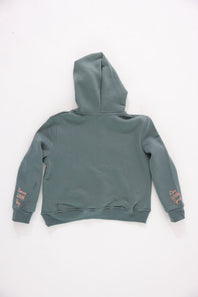 Back view of a girls' gray pullover hoodie featuring pink embroidered cursive text reading “Serve With Joy” on the left sleeve cuff and “Live With Grace” on the right sleeve cuff against a plain light background.