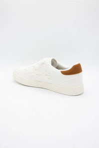 A white low-top sneaker with a textured embossed pattern on the upper and a contrasting brown heel tab, shown from a side profile on a white background.
