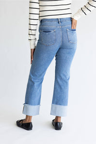 Woman wearing striped shirt with straight leg jeans and cuffed leg. 