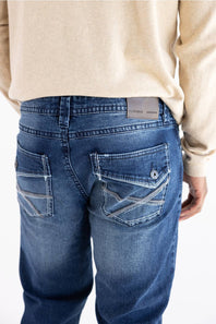 A person wearing Axel Jeans Theo vapor wash straight-leg denim jeans, showing the back pockets with decorative stitching and flap detailing.