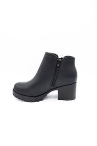 A single black leather ankle boot with a chunky block heel and a textured lug sole, shown from a three-quarters angle on a white background.