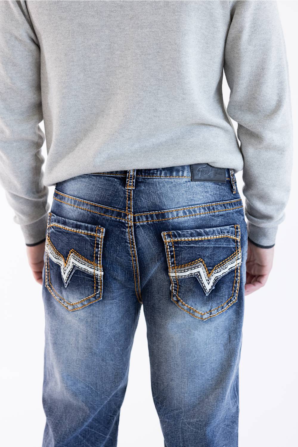 Back view of Men's True Luck Truman Loose Straight jeans in a dark wash, showcasing detailed contrast stitching, decorative embroidery on the back patch pockets, and a black logo patch at the waistband.