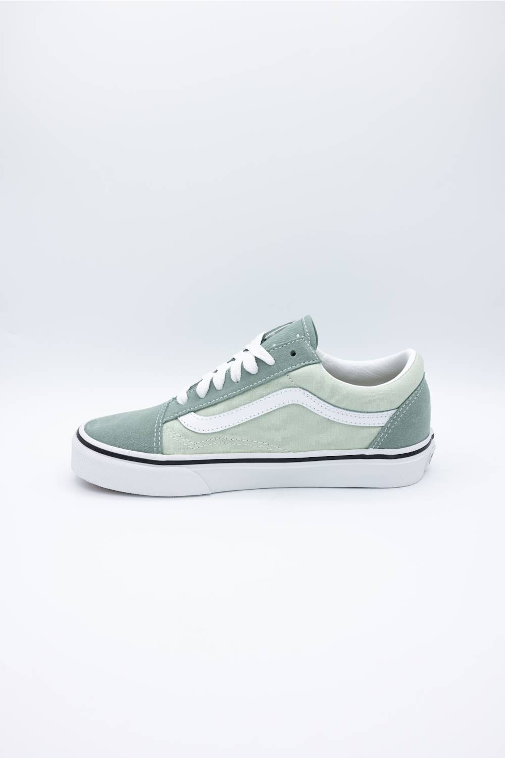 A classic low-top Vans sneaker in a muted sage green colorway, featuring white laces, a white side stripe, and a white rubber sole with a thin black stripe.