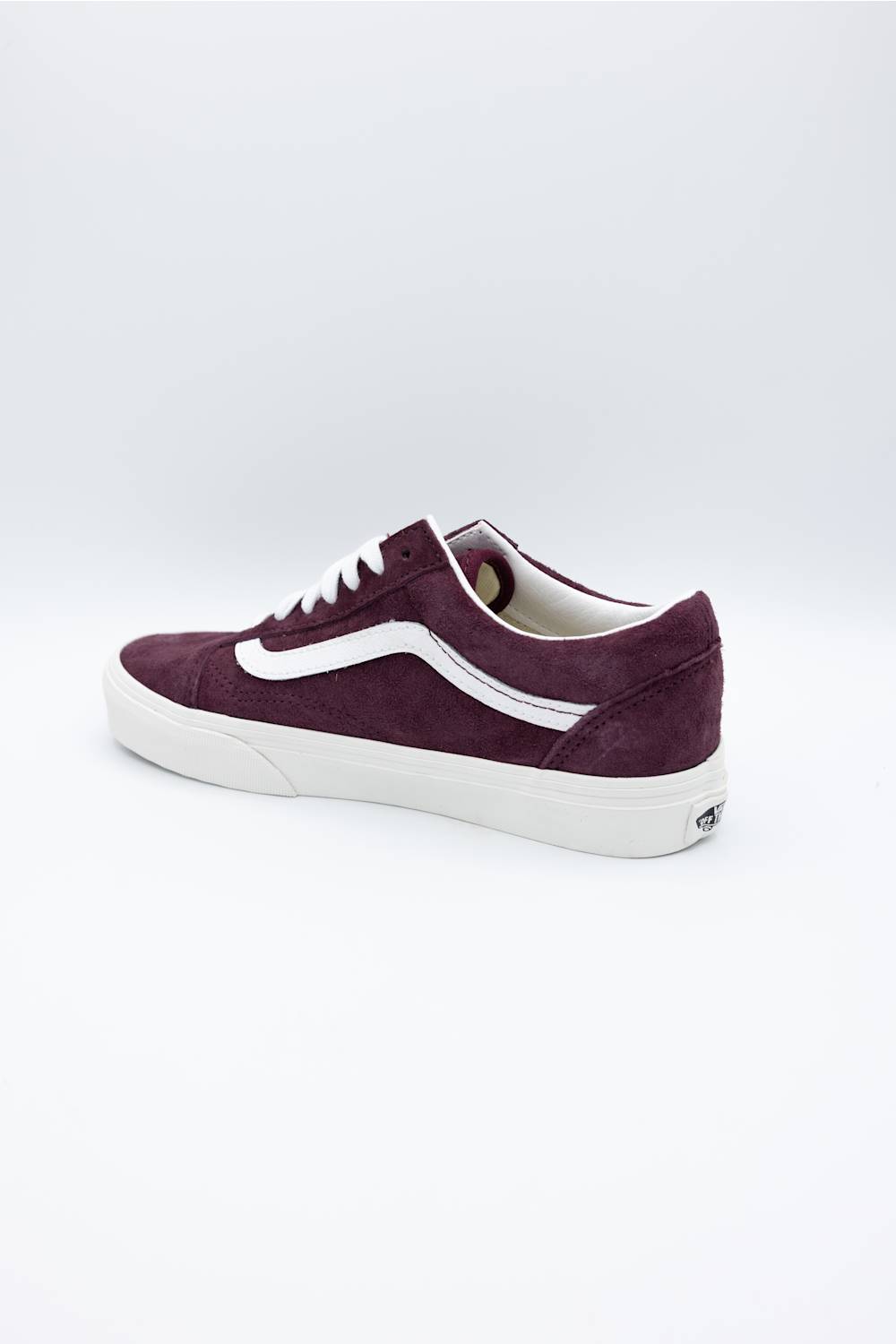 A single Vans Old Skool sneaker in deep burgundy suede with a white side stripe, white laces, and a white rubber sole, shown from a side profile view on a light gray background.