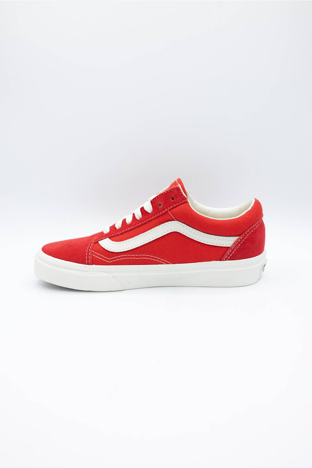 A red Vans Old Skool sneaker with a white side stripe and white laces, shown in a side profile view against a white studio background.