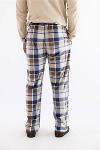 A person shown from the back wearing plaid lounge pants in beige, brown, and blue, with a cream sweater and brown shoes, against a plain white background.
