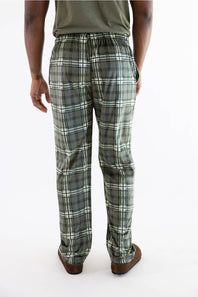 A person shown from the back wearing plaid lounge pants in olive green, gray, and white, with an olive green t-shirt and brown shoes, against a plain white background.