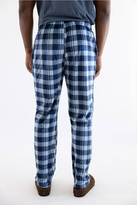A person shown from the back wearing blue and white plaid pants, a dark gray t-shirt, and brown shoes, photographed against a plain white studio background.