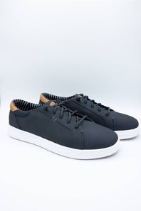 A pair of low-top casual sneakers in dark navy blue with white soles and a light brown leather heel tab, displayed on a clean white studio background.
