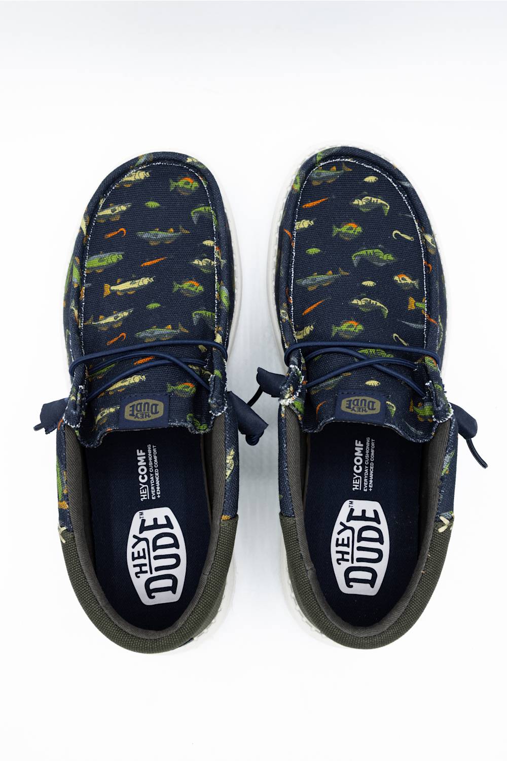 A pair of Vans 'Hey Dude' boat shoes in navy blue canvas with a green, orange, and yellow fish print, shown from a top-down view on a white background.