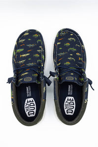 A pair of Vans 'Hey Dude' boat shoes in navy blue canvas with a green, orange, and yellow fish print, shown from a top-down view on a white background.