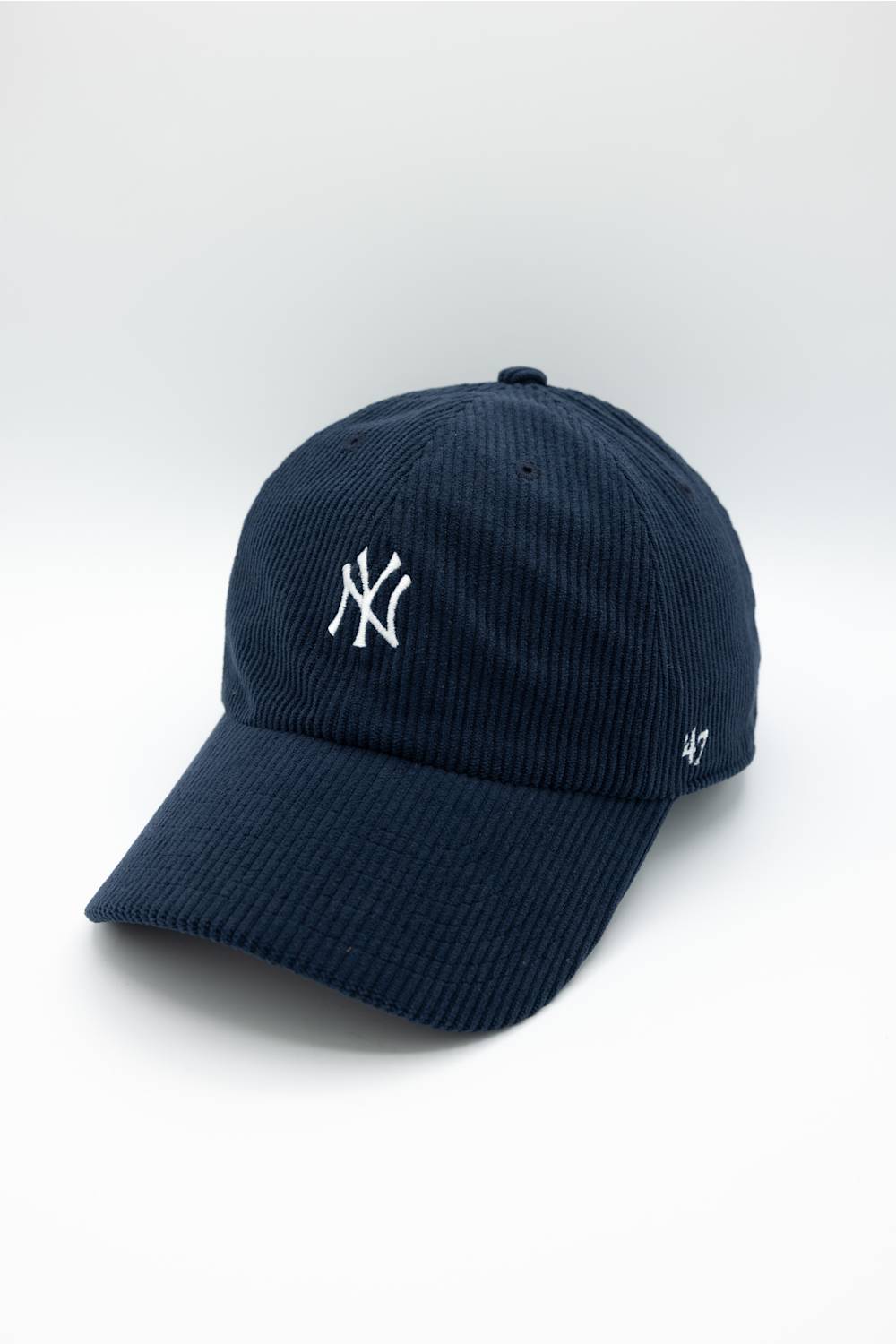 A navy blue corduroy baseball cap featuring a white embroidered New York Yankees logo on the front and a white '47' brand logo on the side, set against a clean white background.