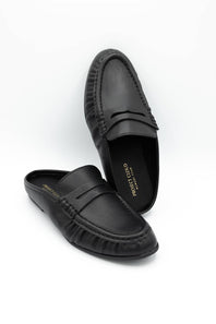 A pair of black leather penny loafers with decorative stitching around the toe, displayed on a clean white background. One shoe is positioned upright and the other lies flat on its side