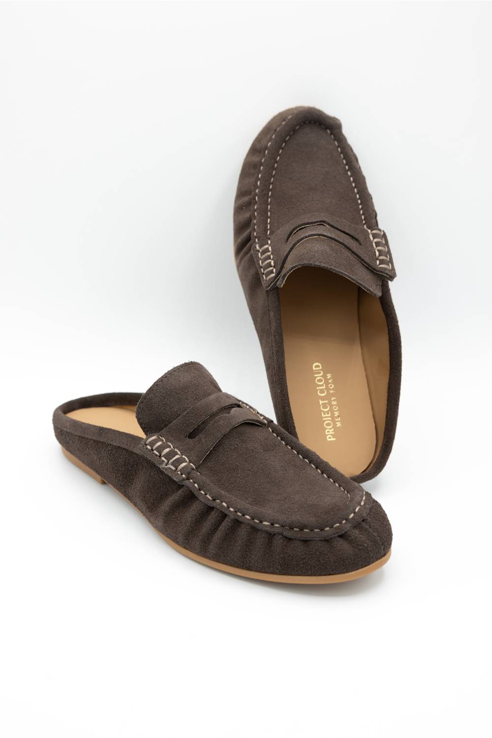 A pair of dark brown suede penny loafers with decorative stitching and a small leather tab on the side, displayed on a clean white background. 