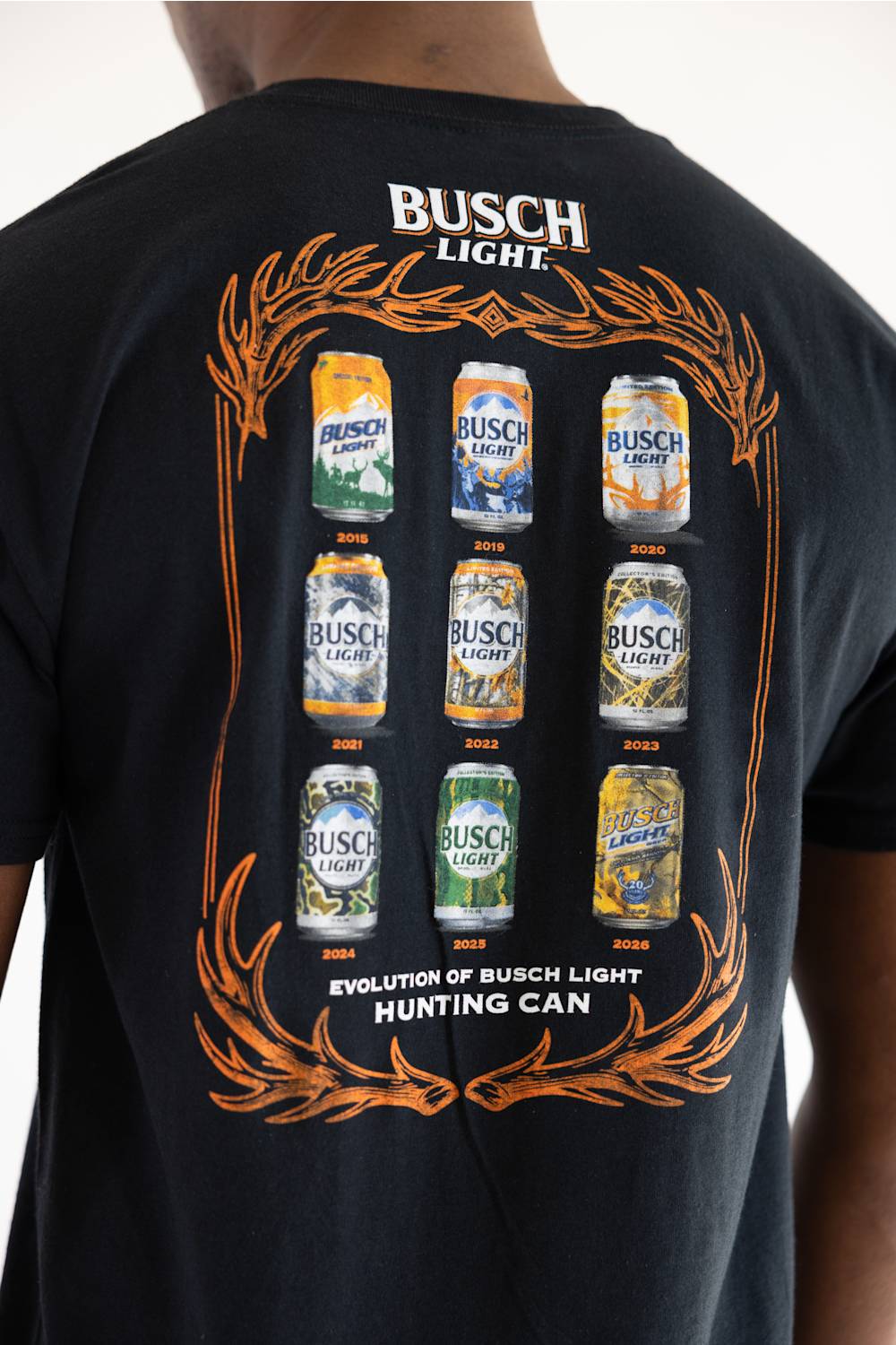 Busch Light Can Evolution T-Shirt for Men in Black (Back View showing graphic design featuring vintage hunting cans from 2015 to 2026 and antler frame).