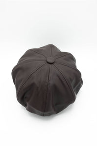 A top-down view of a dark chocolate brown faux leather newsboy hat showcasing its 8-panel structured top and central button, displayed against a clean white background.