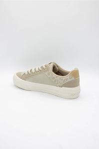 A low-top sneaker in beige and off-white, featuring a textured patterned side panel, beige laces, and a thick white rubber sole, shown from a side-rear angle on a white studio background.