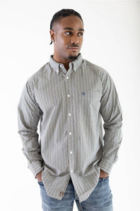 A man wearing a long-sleeve button-down shirt with a small white geometric pattern on a light gray background, paired with blue jeans, photographed against a plain white studio background.
