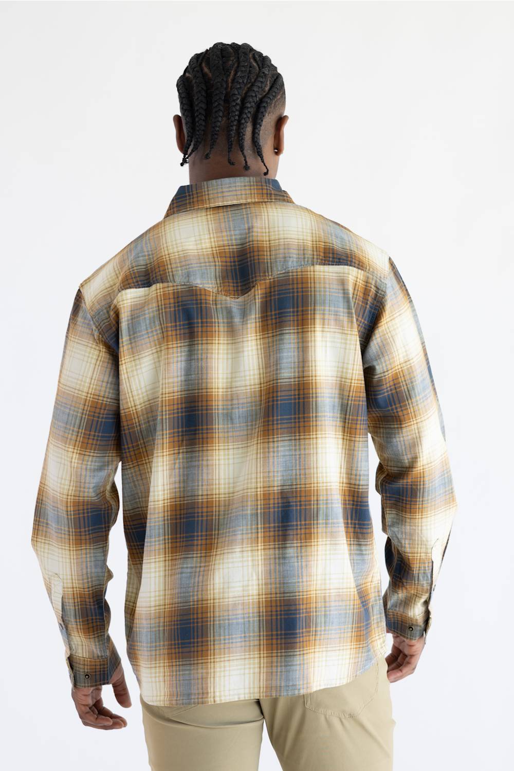 A man viewed from the back wearing a Carhartt long-sleeve plaid button-up shirt in beige, brown, and blue tones, paired with khaki pants, against a plain white background.