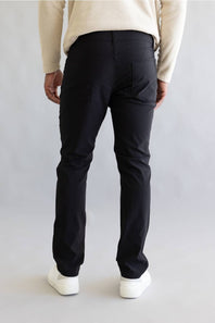 Man wearing black pants and white shoes on a plain background