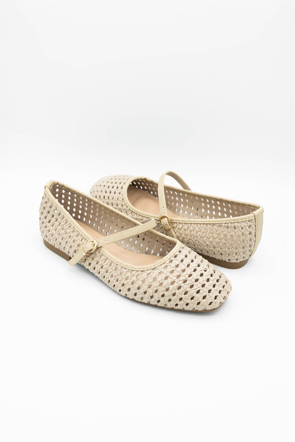 A pair of beige woven flat shoes with Mary Jane straps and small gold-tone buckle details, displayed on a clean white background.