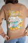 A person wearing a tan long-sleeve shirt from the back, featuring a large autumn-themed graphic with pumpkins, flowers, and the words 'Grateful Thankful Blessed' and 'simply southern COLLECTION'.