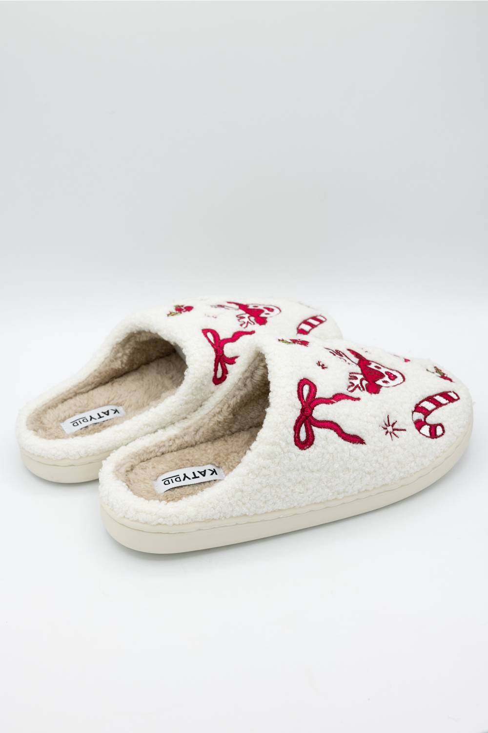 side profile of holiday themed slippers with bows and deer motifs 