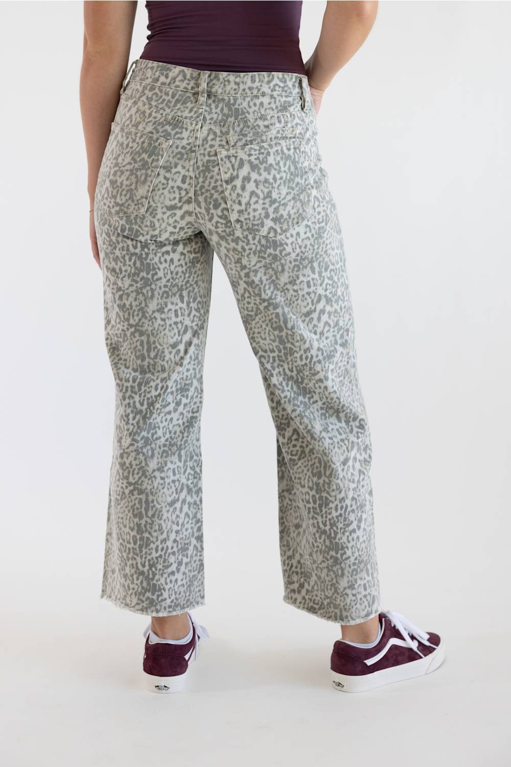 Back view of high-waisted wide-leg cropped pants in light grey leopard print, showing back pockets and raw hems.