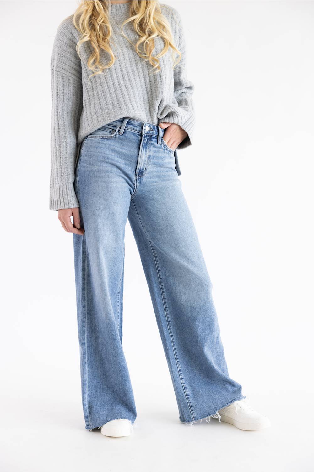 Flying Monkey high-rise medium wash wide-leg denim jeans modeled with a cropped grey sweater and white sneakers