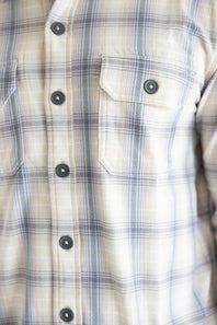 Close-up front view of the Hallstatt Knit Button Up Flannel Shirt in Sand showcasing two button-down flap chest pockets, dark buttons, and a beige, blue, and gray plaid pattern