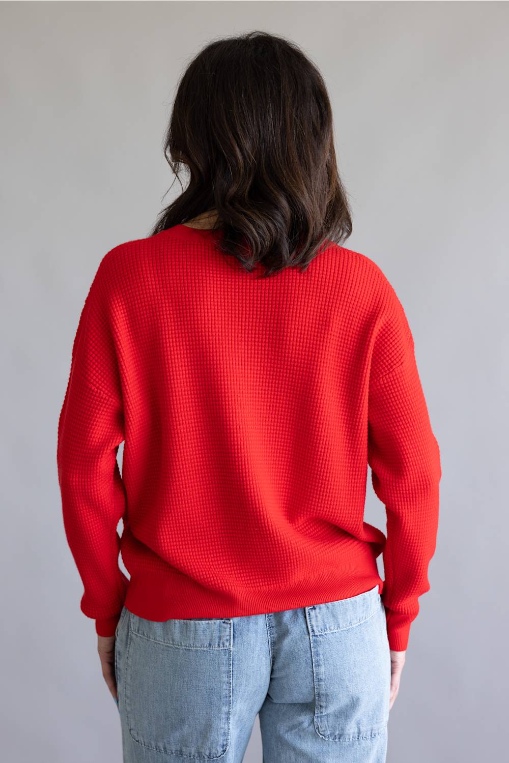 Waffle textured sweater top in a vibrant red color, with thick hems and cuffs 