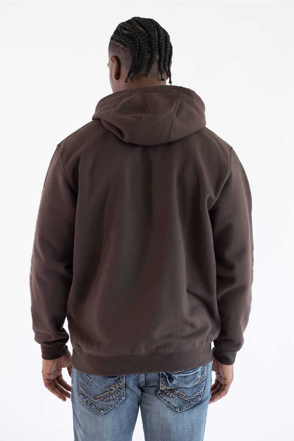 Back view of a male model against a plain white background, wearing a dark clove brown Carhartt hooded sweatshirt with the hood down, paired with medium wash denim jeans.
