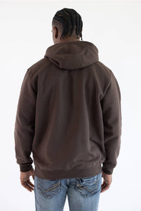 Back view of a male model against a plain white background, wearing a dark clove brown Carhartt hooded sweatshirt with the hood down, paired with medium wash denim jeans.