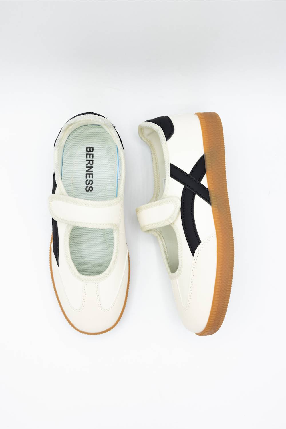 A pair of Onitsuka Tiger BERNESS low-top sneakers in off-white, featuring black side stripes and a brown gum sole, shown from top and side views on a light gray background.