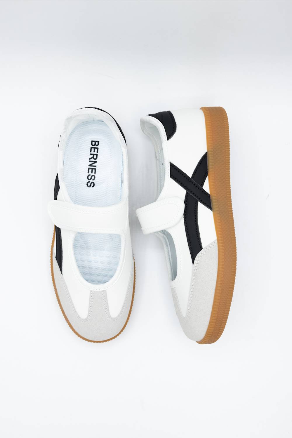 A pair of white Berness slip-on sneakers with black side stripes and a brown gum sole, shown from a top-down view on a white background.