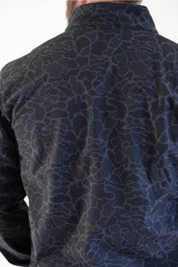 Close-up back view of a man wearing a dark navy long-sleeve shirt with a subtle blue-gray abstract organic pattern.