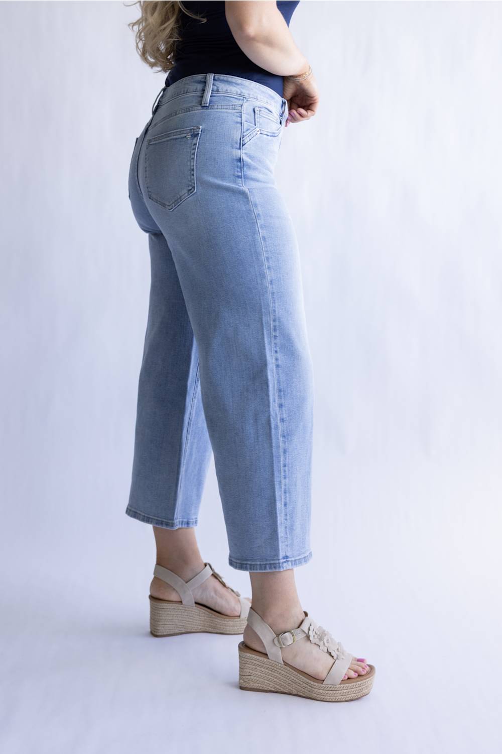 Mica Mid Rise Wide Crop Jeans for Women; Person wearing light blue jeans and beige sandals on a white background