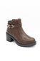 A brown faux-leather ankle boot with a chunky black block heel, a decorative strap across the ankle featuring a gold-tone buckle, and a rugged lug sole, shown against a plain white background.