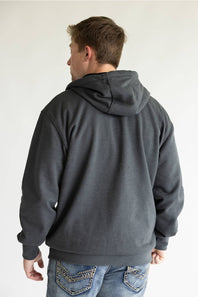A man viewed from behind wearing a dark charcoal gray pullover hoodie and blue jeans with decorative stitching on the back pockets, set against a plain light gray background.