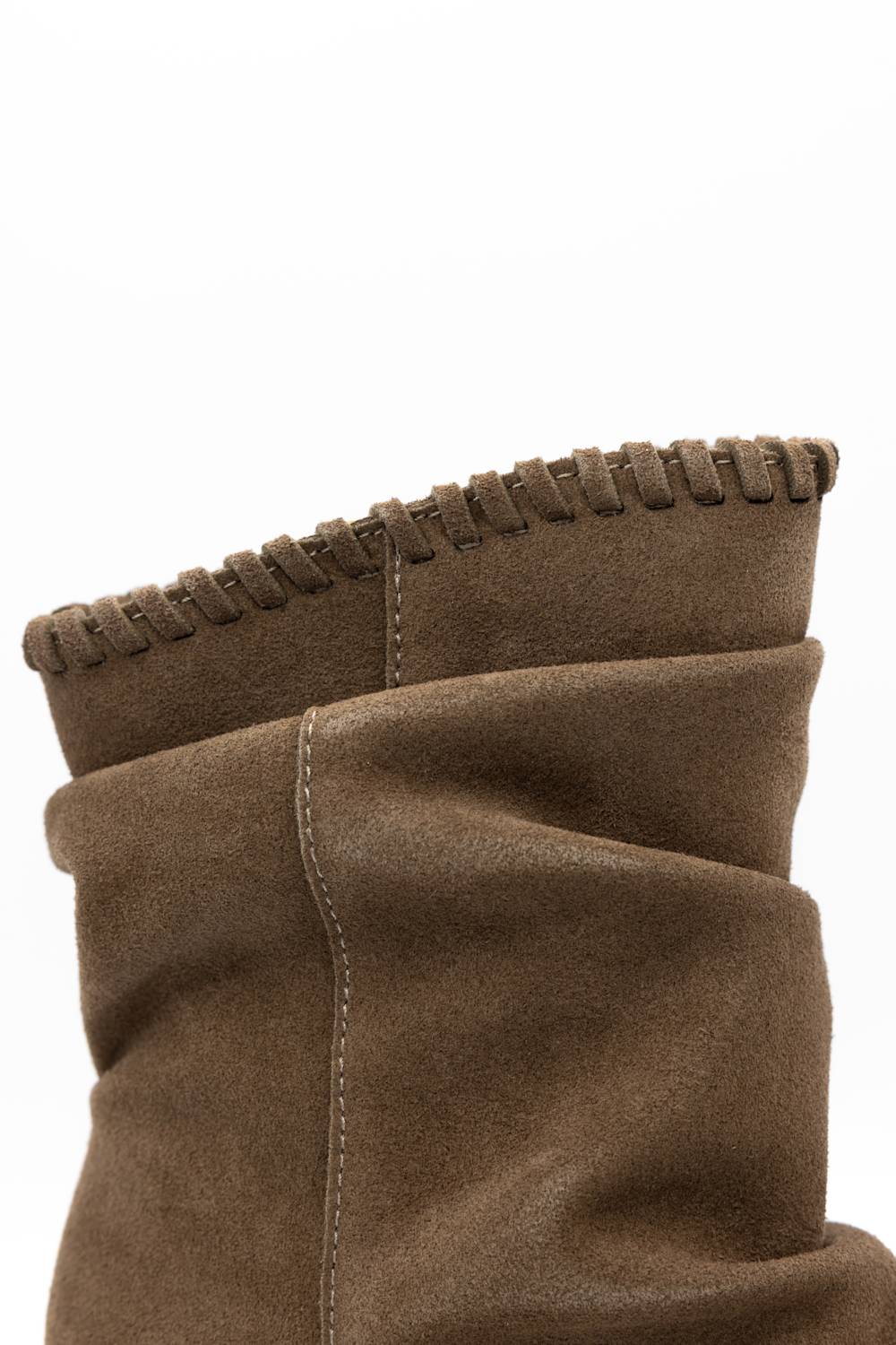 Close-up of a brown suede boot with a fringed edge and stitched details on a white background.